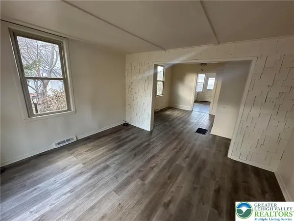 wooden floor in an empty room with a window