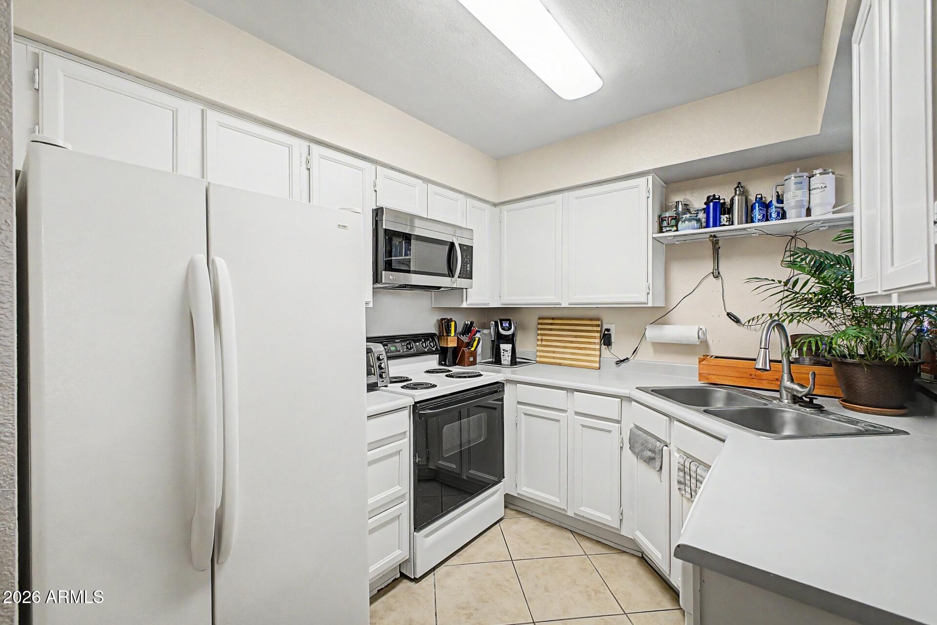 533 West Guadalupe Road, Unit 1104 Mesa, AZ 85210 - Photo 4 of 20 a kitchen with stainless steel appliances a stove refrigerator sink and cabinets