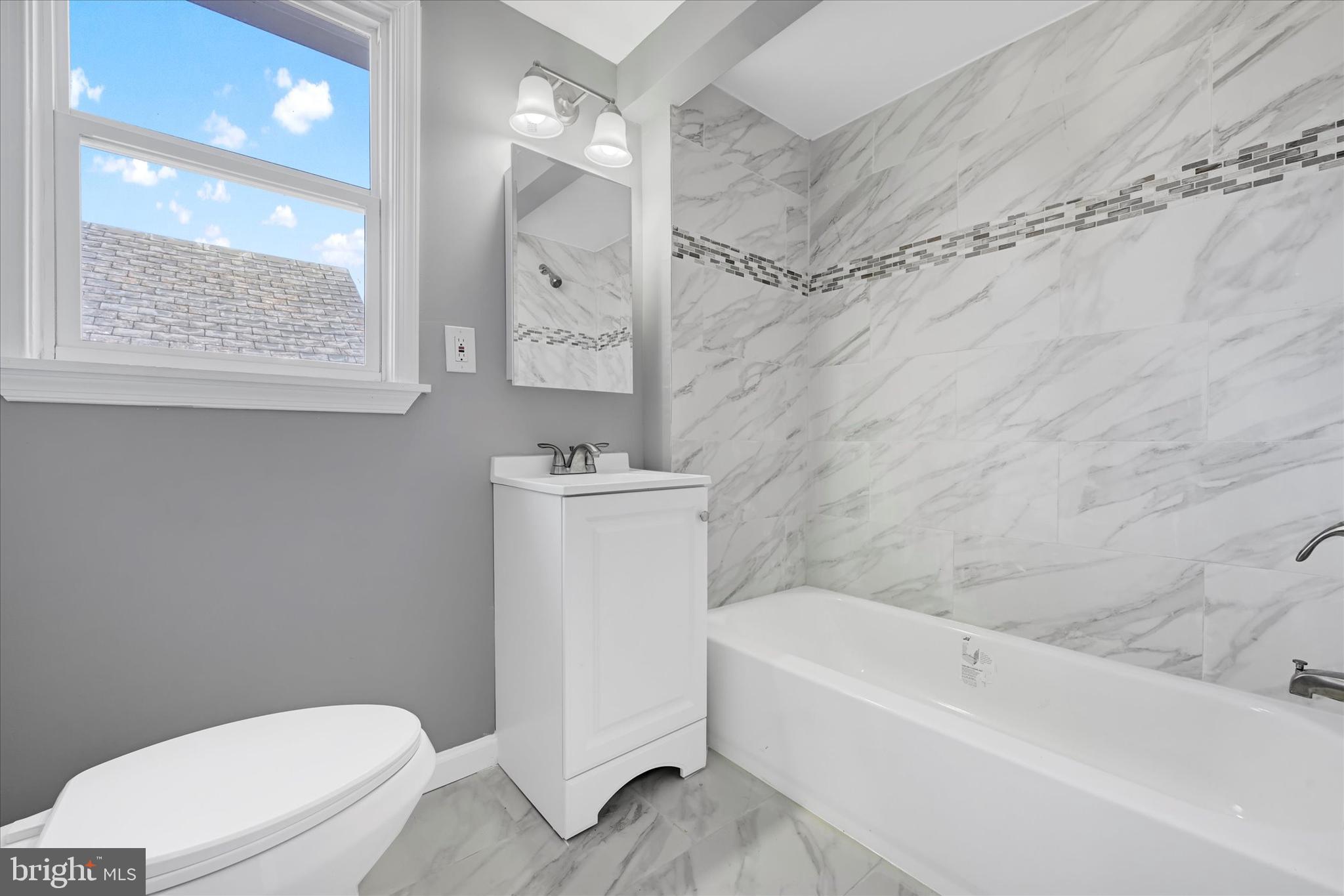 6113 Sefton Avenue Baltimore, MD 21214 - Photo 20 of 25 a bathroom with a sink a toilet and a bathtub