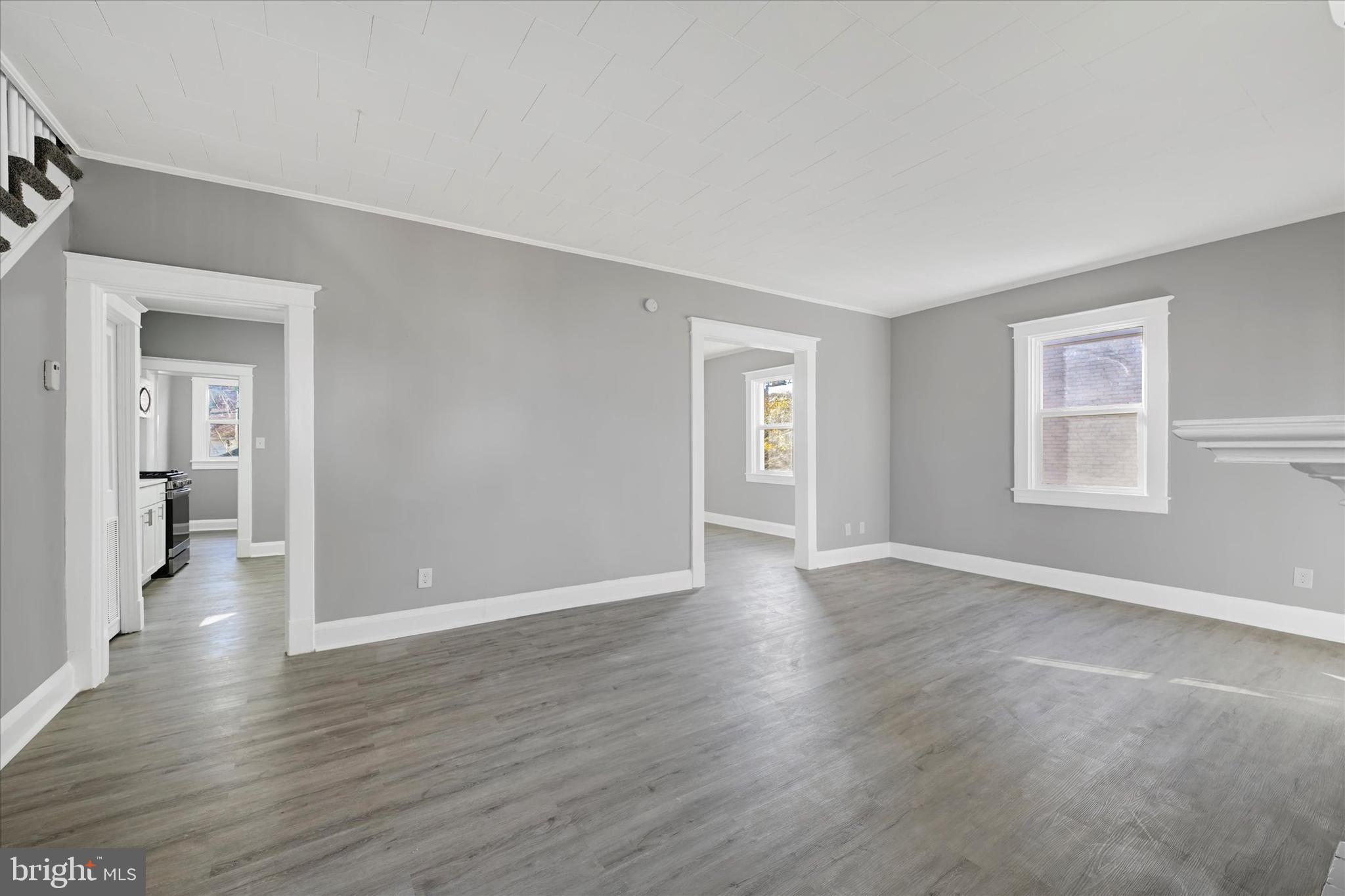 6113 Sefton Avenue Baltimore, MD 21214 - Photo 3 of 25 a view of an empty room with wooden floor and a window