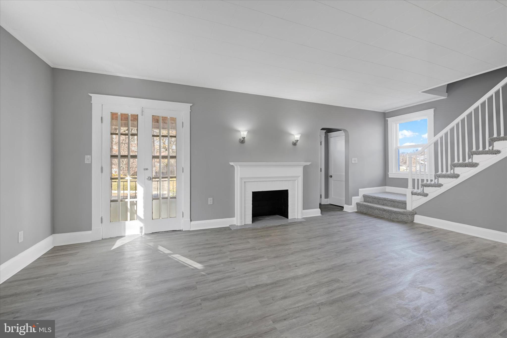6113 Sefton Avenue Baltimore, MD 21214 - Photo 5 of 25 a view of a livingroom with wooden floor fireplace and windows