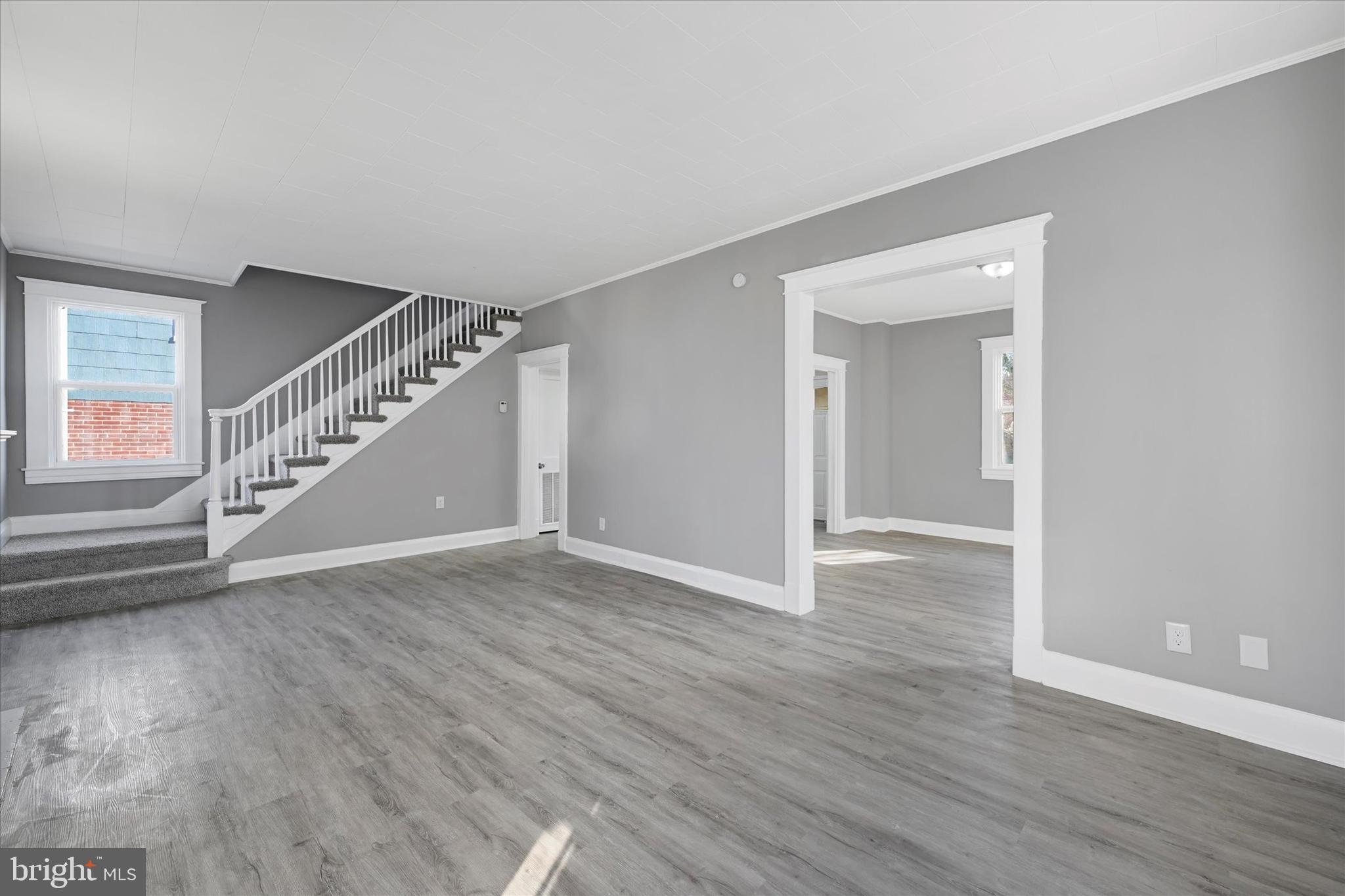 6113 Sefton Avenue Baltimore, MD 21214 - Photo 6 of 25 a view of an empty room with wooden floor and stairs