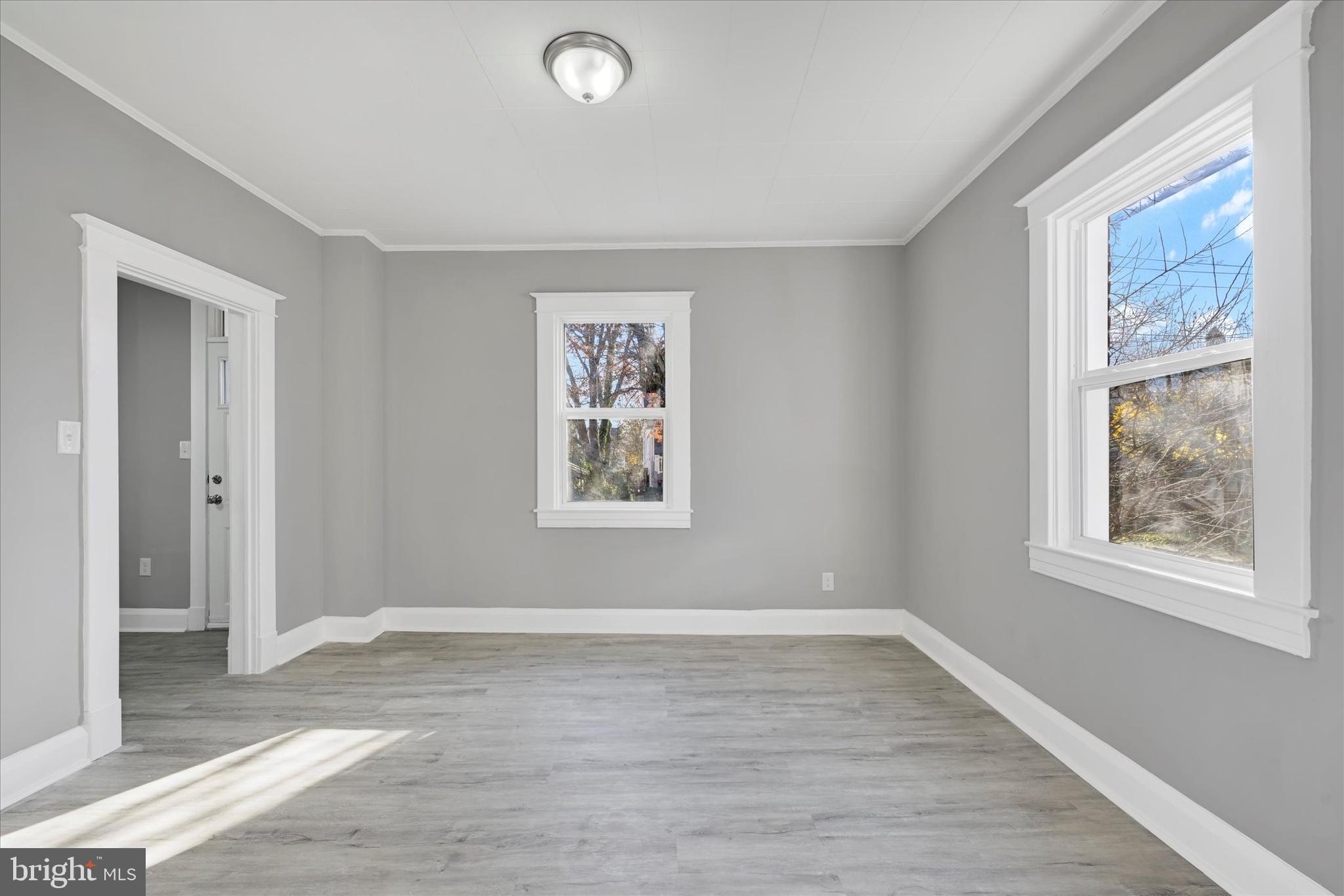 6113 Sefton Avenue Baltimore, MD 21214 - Photo 7 of 25 a view of a big room with wooden floor and windows