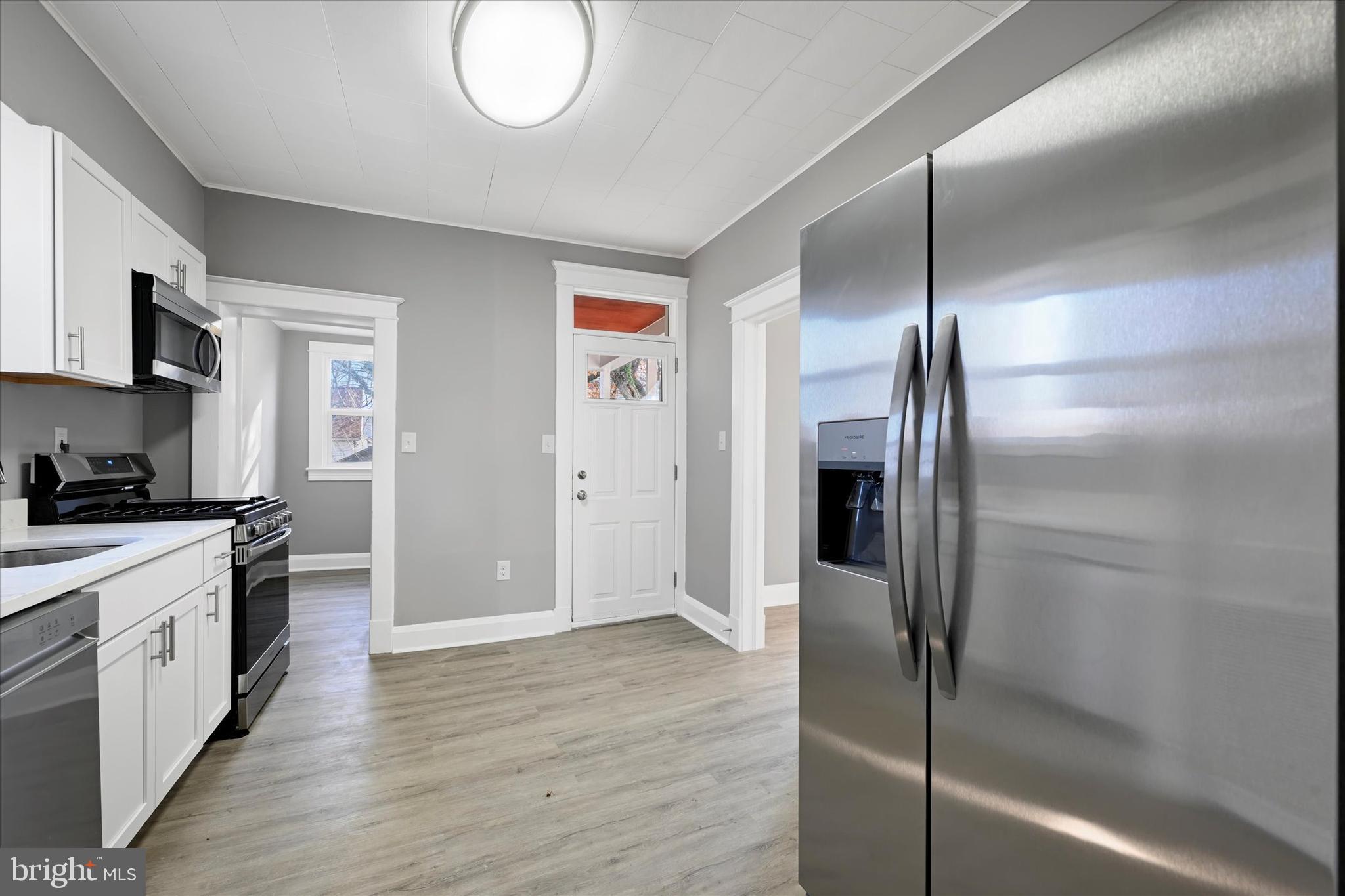6113 Sefton Avenue Baltimore, MD 21214 - Photo 10 of 25 a kitchen with stainless steel appliances granite countertop a refrigerator and a stove