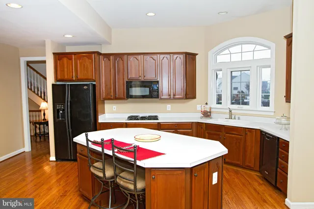 a kitchen with a sink a refrigerator and a stove top oven