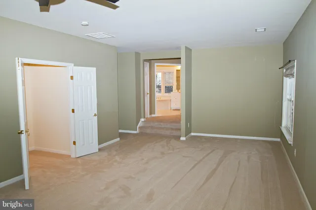 an empty room with closet and windows