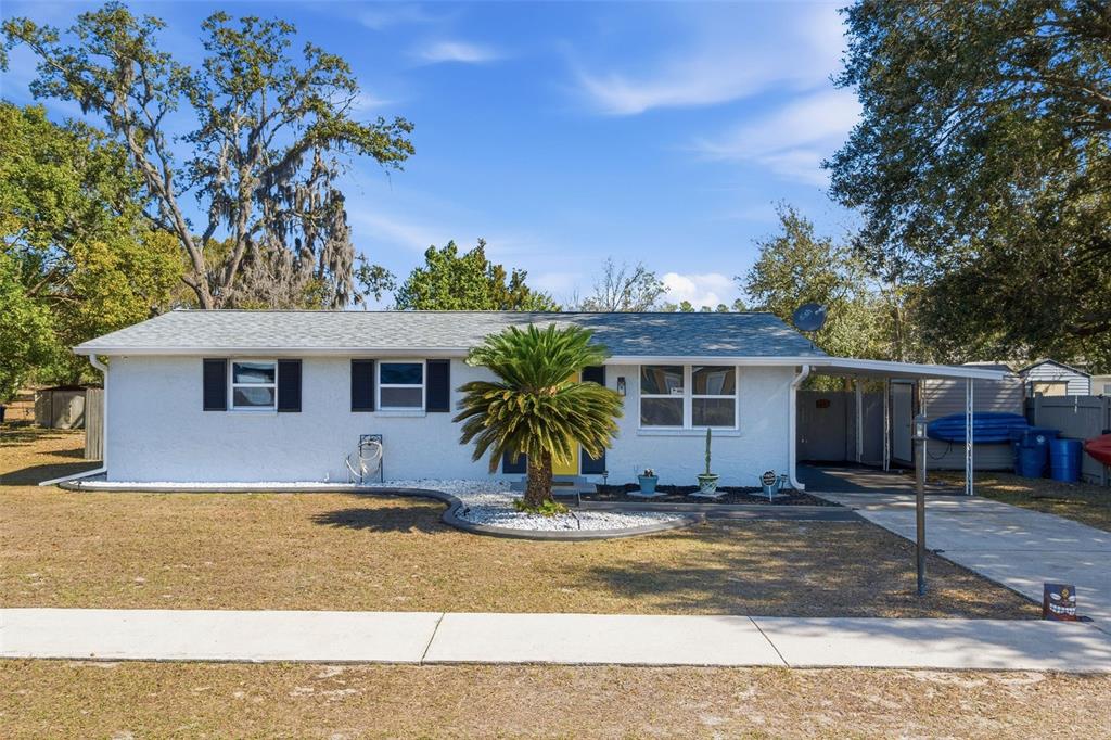 9381 Rosa Street Spring Hill, FL 34608 - Photo 1 of 26 a view of a house with a yard