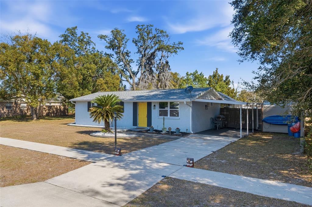 9381 Rosa Street Spring Hill, FL 34608 - Photo 2 of 26 a front view of a house with a tree
