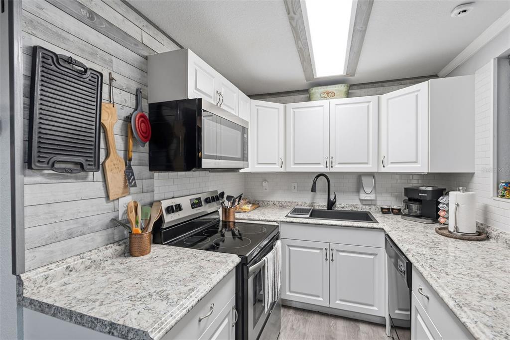 9381 Rosa Street Spring Hill, FL 34608 - Photo 7 of 26 a kitchen with a sink stove and cabinets