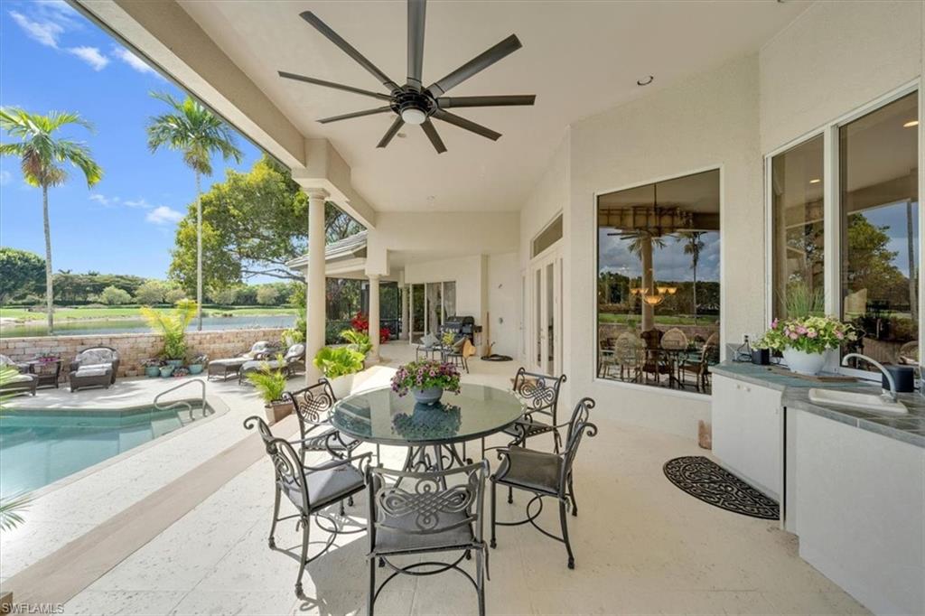 2339 Alexander Palm Naples, FL 34105 - Photo 18 of 45 a view of a patio with a dining table and chairs with a yard