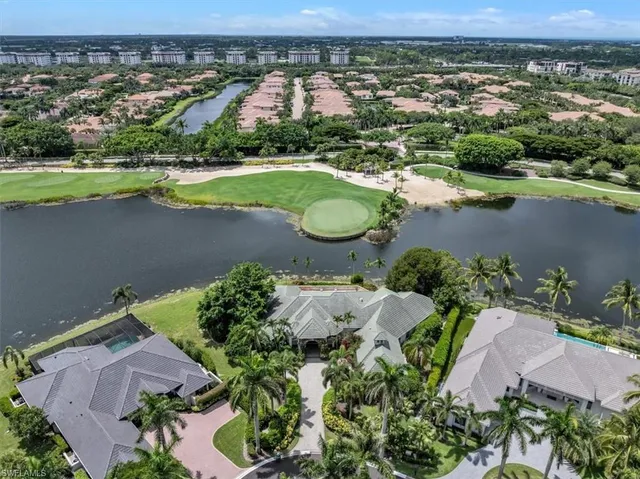 an aerial view of a residential houses with outdoor space and lake view