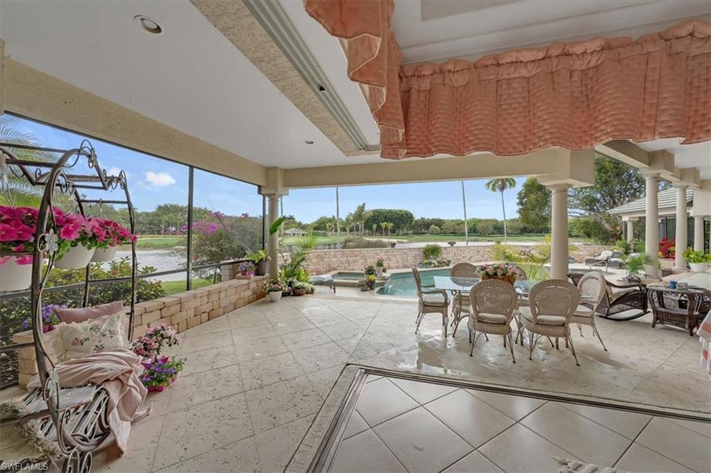 2339 Alexander Palm Naples, FL 34105 - Photo 34 of 45 a view of a patio with a table and chairs under an umbrella