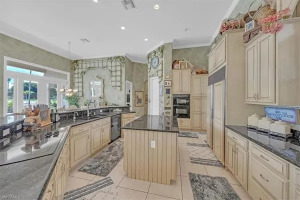 a kitchen with stainless steel appliances kitchen island granite countertop a dining table and chairs