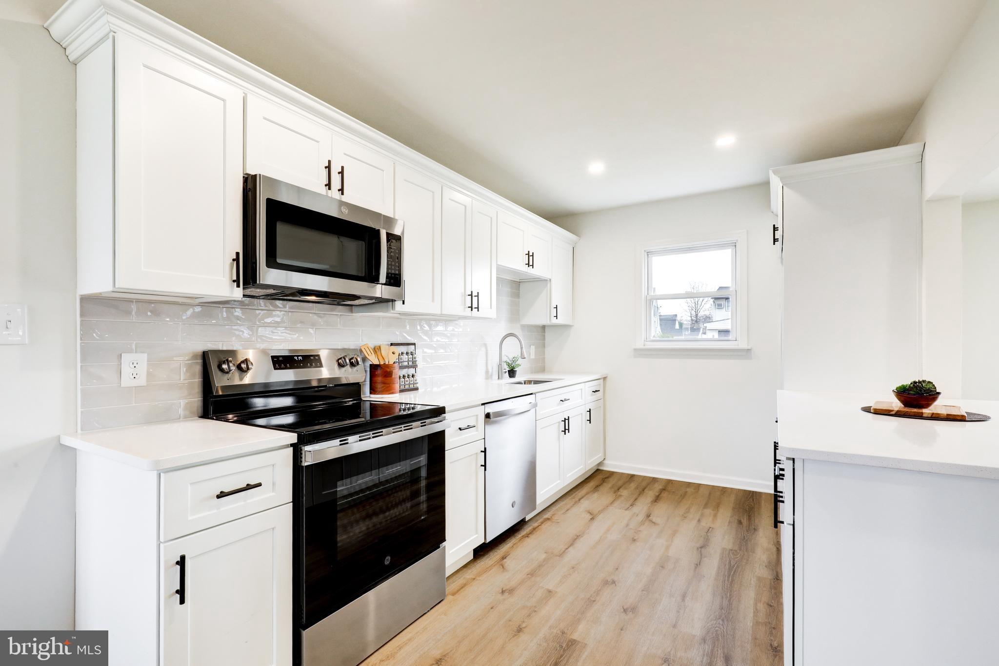31 Nature Lane Levittown, PA 19054 - Photo 6 of 33 a kitchen with stainless steel appliances a stove sink microwave and cabinets