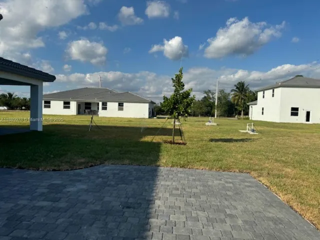 a view of a big yard with a house in the background