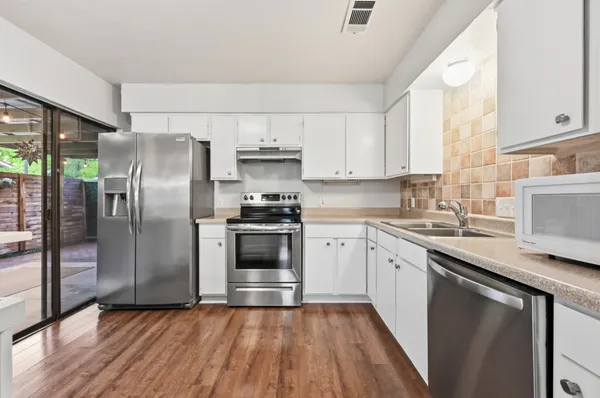 a kitchen with granite countertop a refrigerator stove and sink
