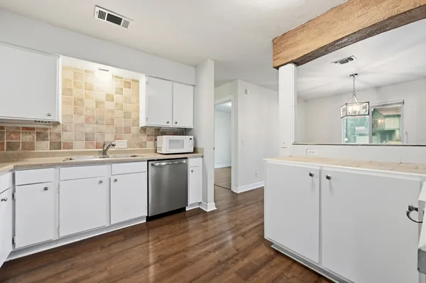 a kitchen with granite countertop white cabinets and white appliances
