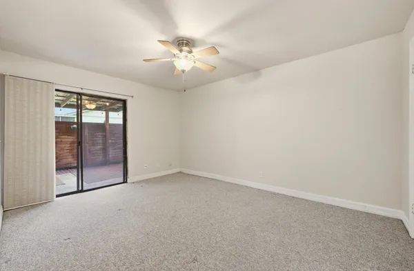 an empty room with chandelier fan
