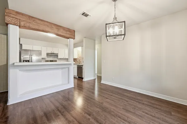 a room with stainless steel appliances granite countertop a hardwood floor sink and kitchen view