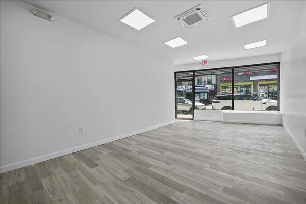 an empty room with wooden floor and glass door