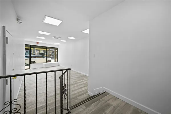 a view of a hallway with wooden floor and staircase