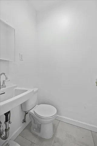 a white toilet sitting next to a white sink and vanity