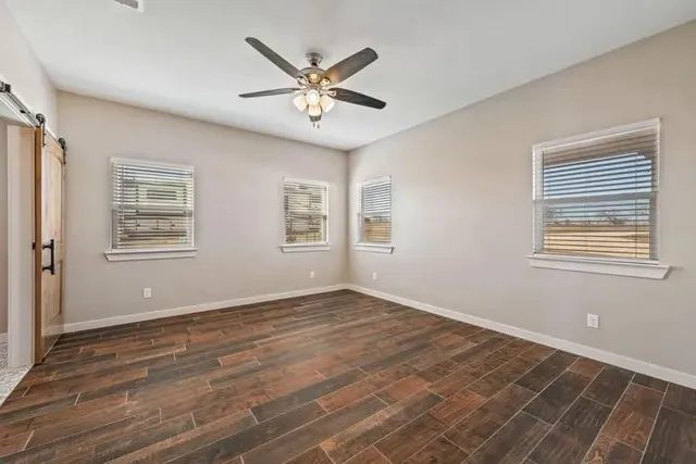 a view of a big room with wooden floor and windows