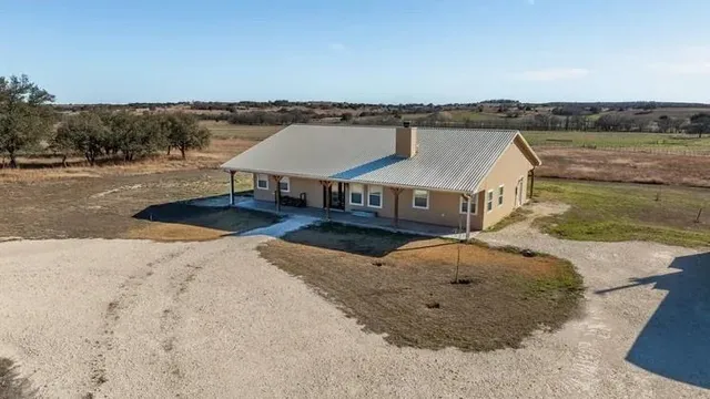 a aerial view of a house with a yard and lake view