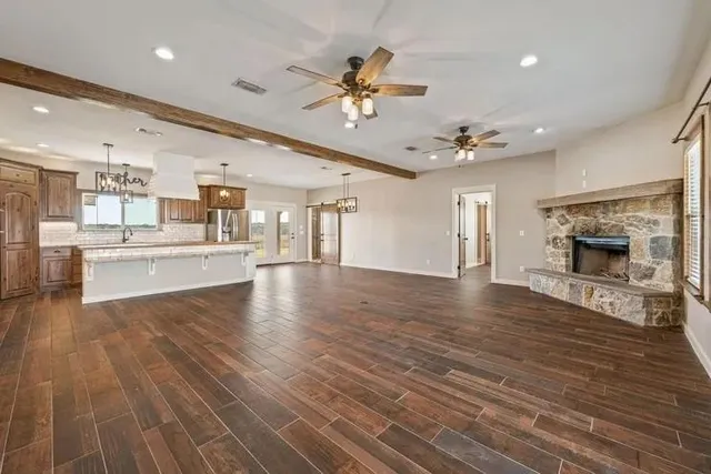 a view of a living room and kitchen with furniture a fireplace
