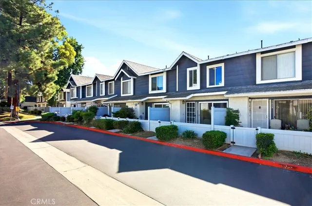 a front view of a house with lots of trees and plants
