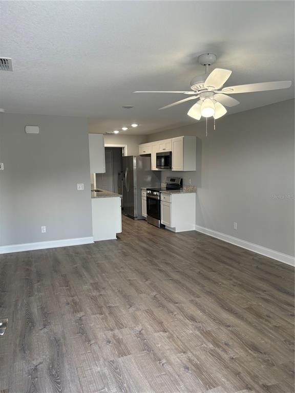 514 2nd Street Southwest Fort Meade, FL 33841 - Photo 7 of 21 a view of a kitchen with a dishwasher a kitchen island with wooden floor and a ceiling fan