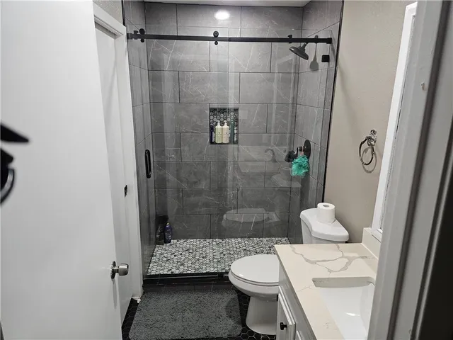 a bathroom with a toilet a sink and shower