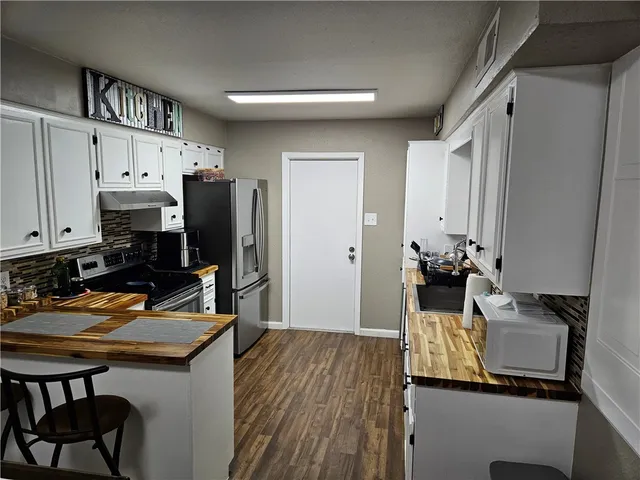 a kitchen with a refrigerator and a stove top oven