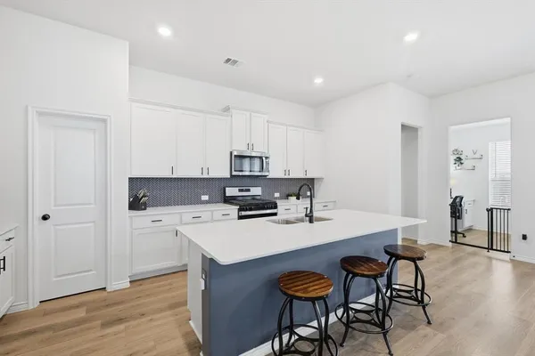 a kitchen with a sink cabinets and wooden floor