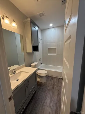 an empty room with a ceiling fan and wooden floor