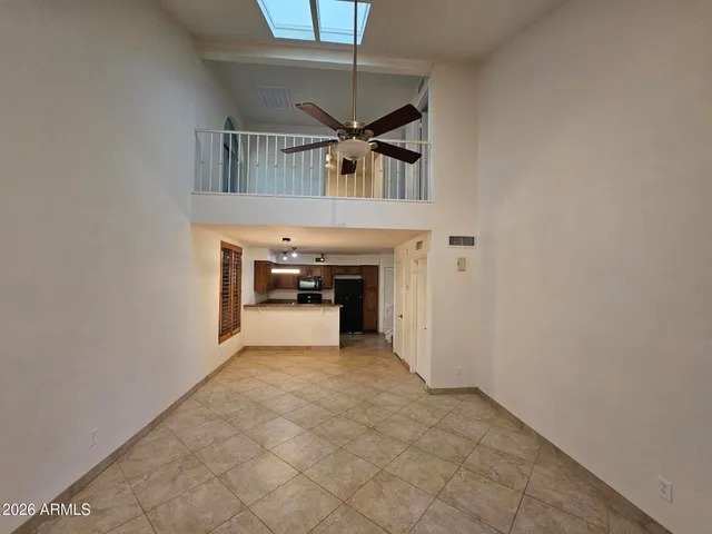 an empty room with windows and ceiling fan view