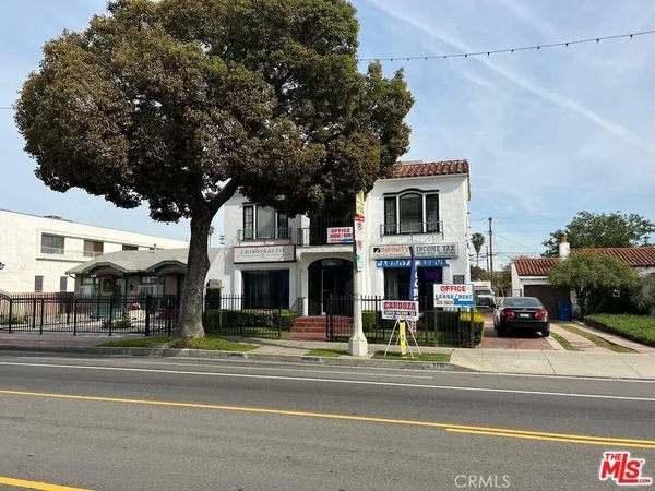 a view of a building and a cars park side of the road