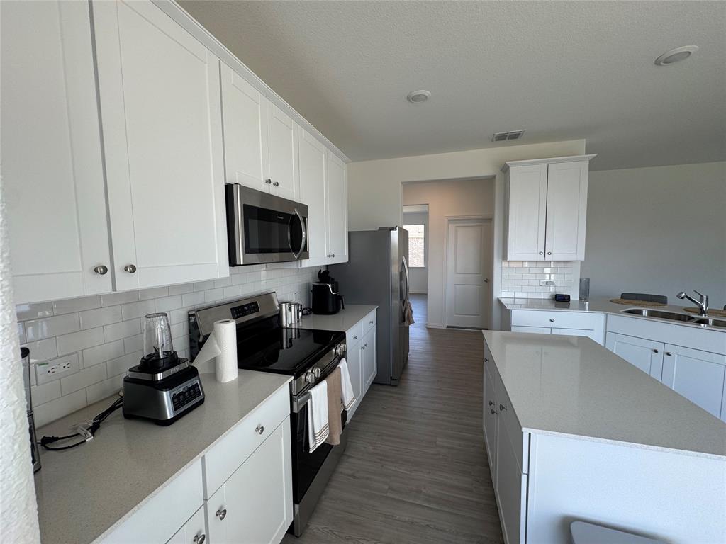 4905 Sagerun Drive Princeton, TX 75407 - Photo 12 of 25 a kitchen with a sink stove and refrigerator