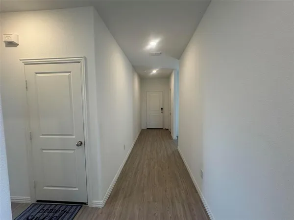 a view of a hallway with wooden floor