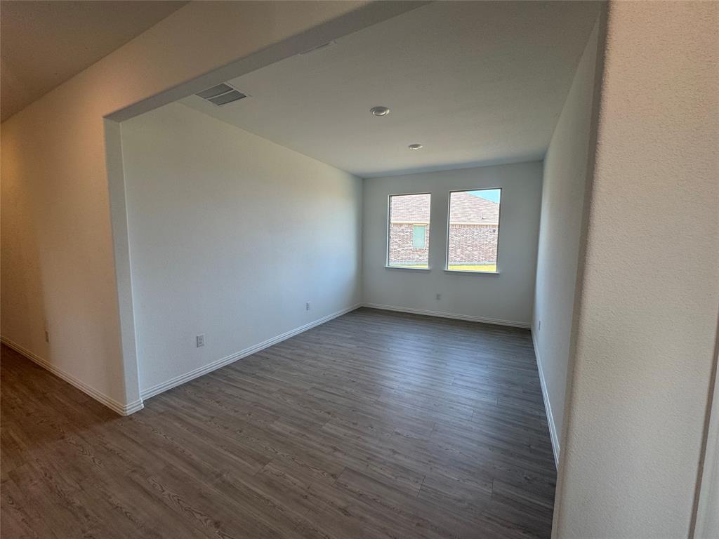 4905 Sagerun Drive Princeton, TX 75407 - Photo 5 of 25 an empty room with wooden floor and windows