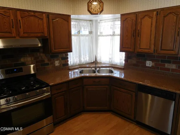 a kitchen with granite countertop a stove sink and cabinets