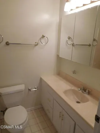 a bathroom with a toilet sink vanity and mirror