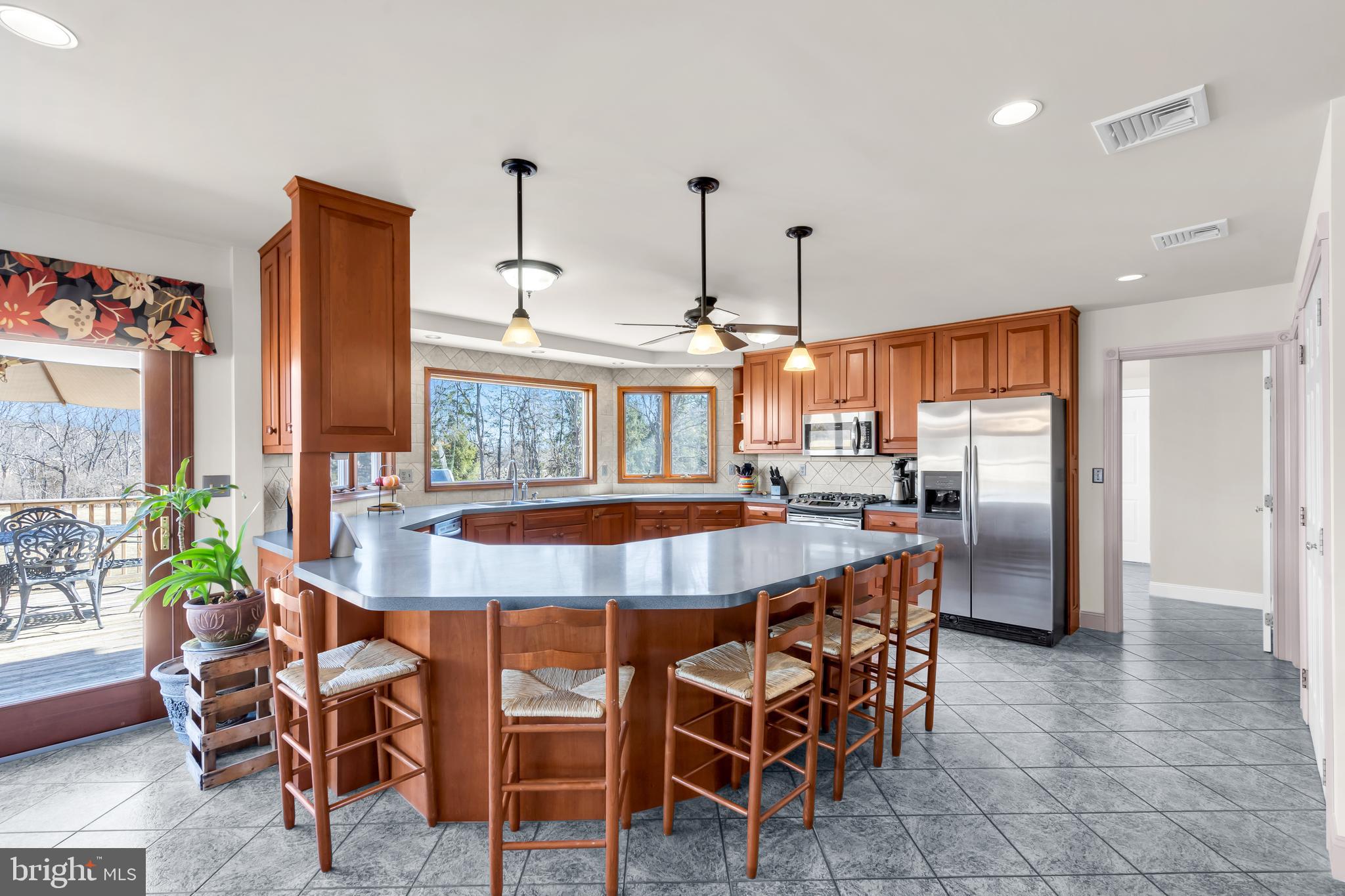309 Pennington Harbourton Road Pennington, NJ 08534 - Photo 11 of 67 a dining hall with stainless steel appliances kitchen island granite countertop a table chairs and a refrigerator
