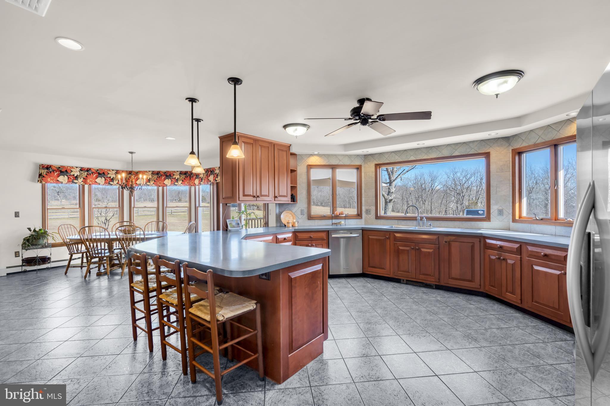309 Pennington Harbourton Road Pennington, NJ 08534 - Photo 12 of 67 a kitchen with stainless steel appliances granite countertop a stove a refrigerator a sink a dining table and chairs with wooden floor