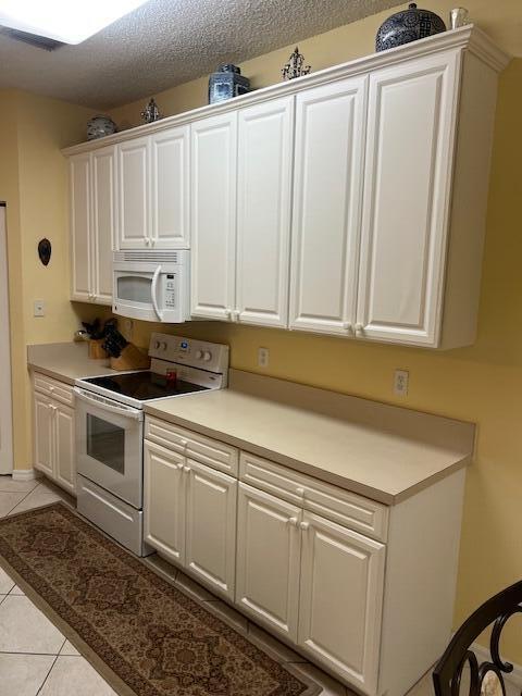 106 Lighthouse Circle, Unit G Tequesta, FL 33469 - Photo 18 of 34 a kitchen with white cabinets and white appliances
