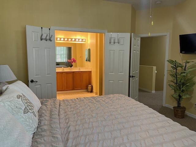 106 Lighthouse Circle, Unit G Tequesta, FL 33469 - Photo 24 of 34 a bedroom with a bed and a television in it
