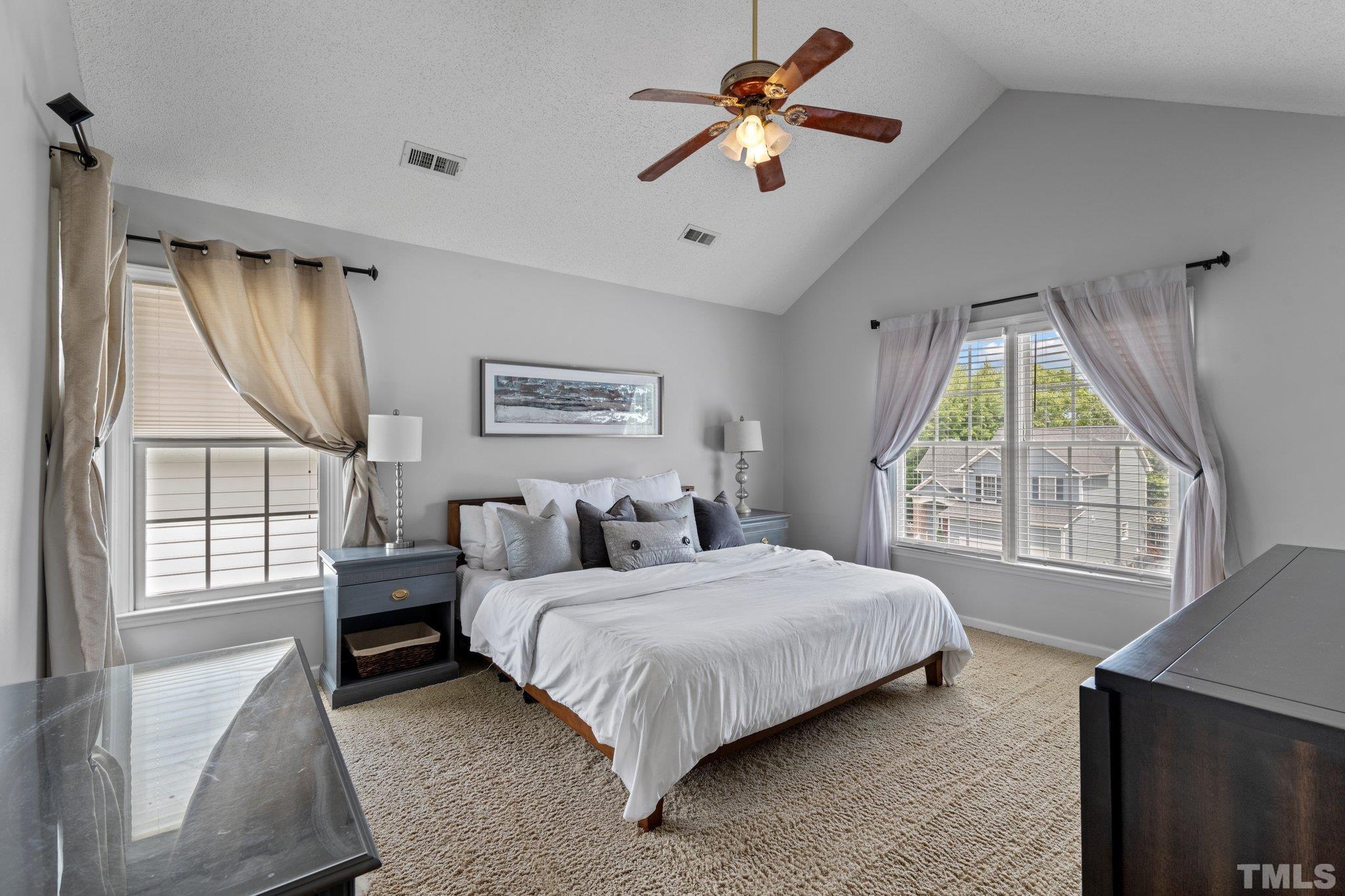 5217 Denmead Way Raleigh, NC 27613 - Photo 18 of 30 a bedroom with a large bed and a chandelier fan