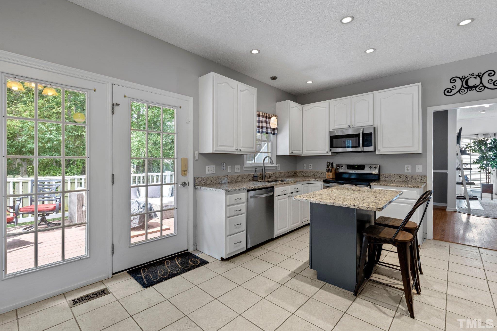 5217 Denmead Way Raleigh, NC 27613 - Photo 8 of 30 a kitchen with stainless steel appliances granite countertop a stove a sink a microwave and a refrigerator