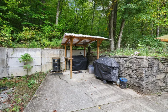a view of a house with a yard and table and chairs under an umbrella