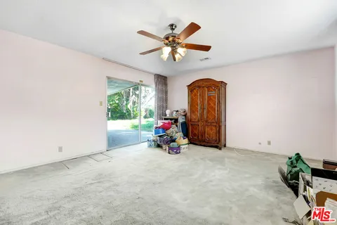an empty room with window and ceiling fan